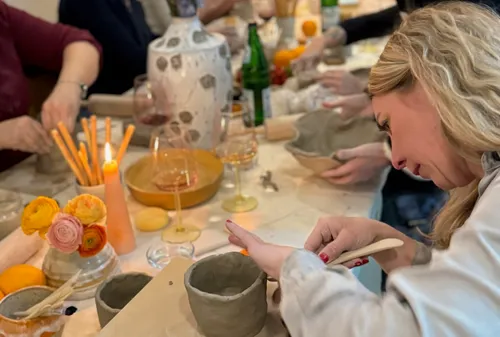 People crafting pottery in a cozy setting.