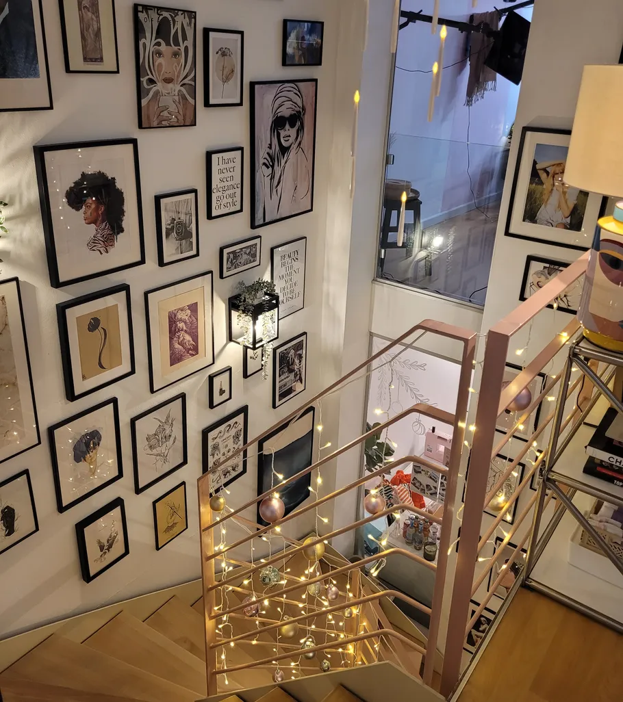 Treppe mit Bildern und Lichterketten.