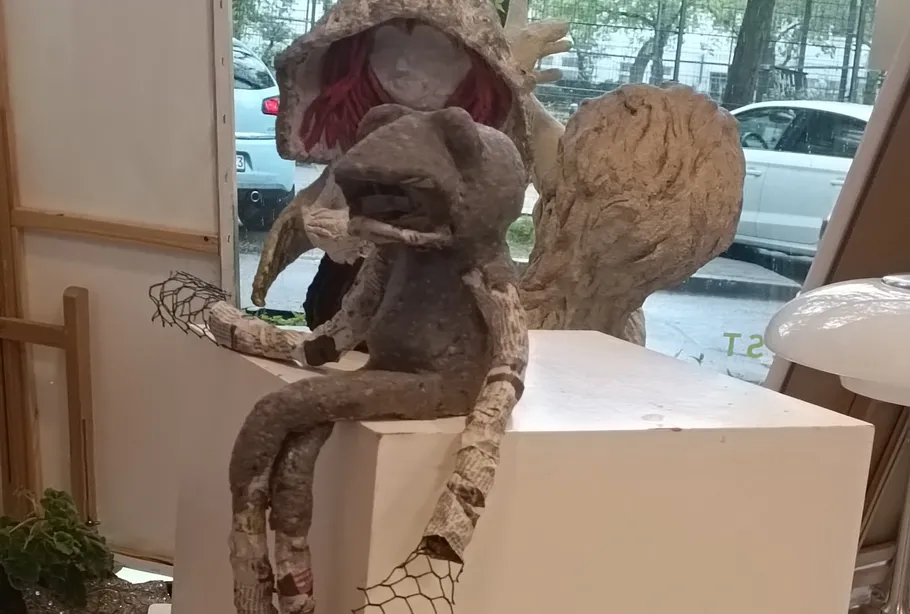 Skulpturen von Figuren sitzen drinnen am Fenster.