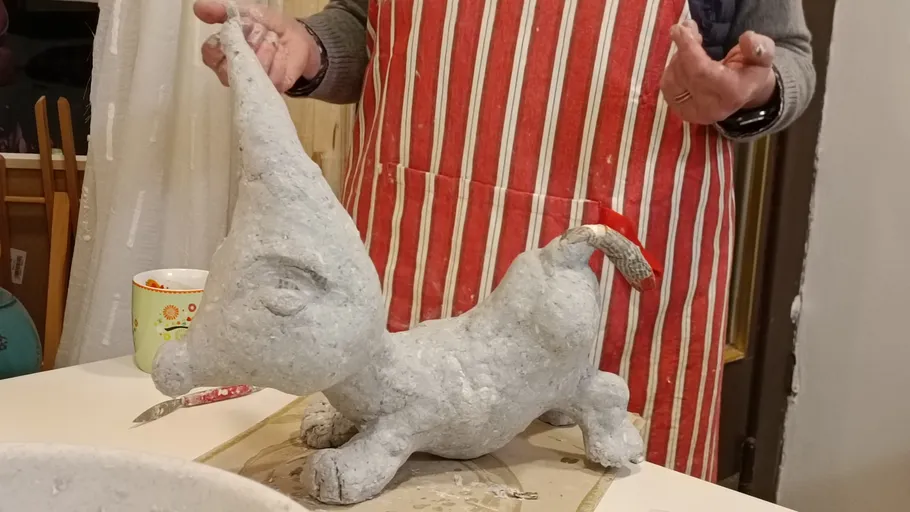 Person crafting clay model in kitchen.