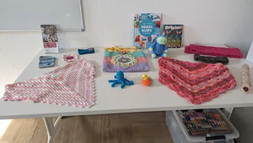 Gehäkelte Gegenstände auf einem Tisch präsentiert.
