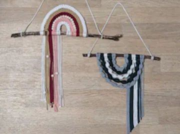 Two macramé hangings on wooden surface.
