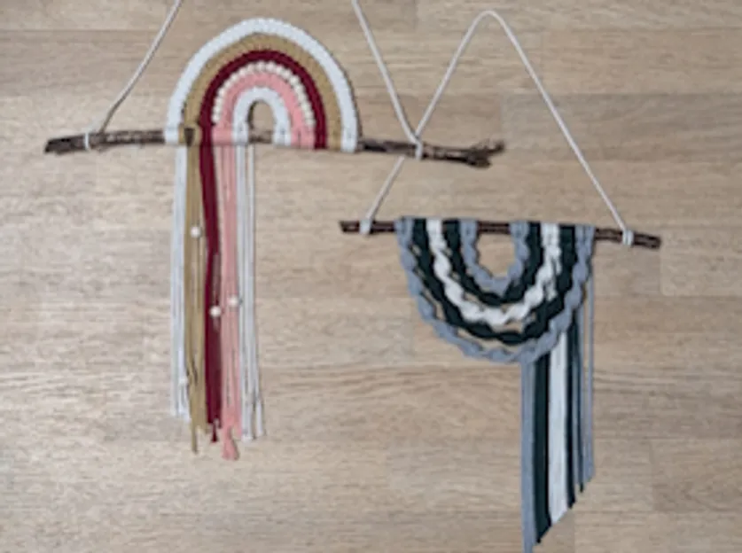 Two macramé hangings on wooden surface.