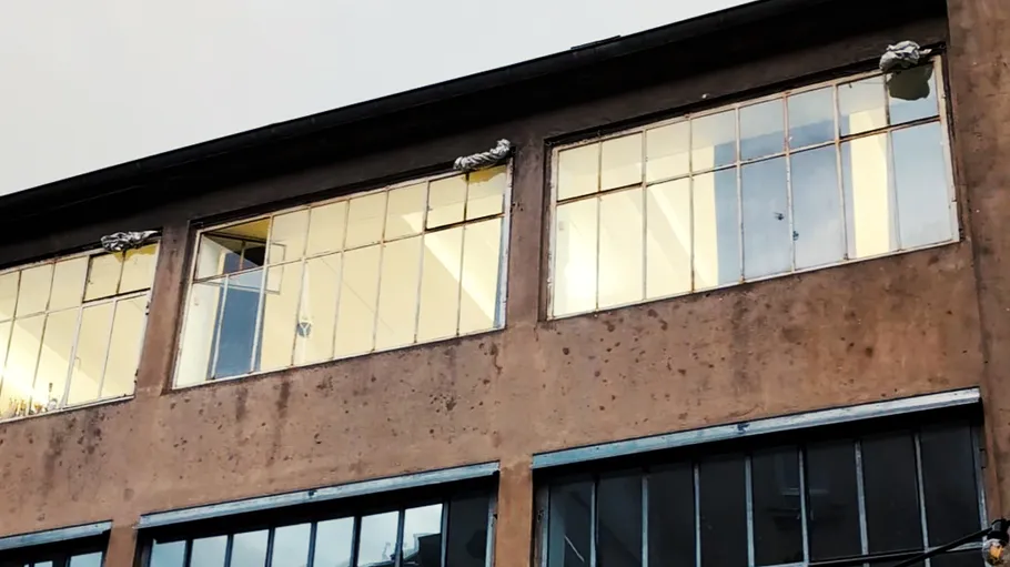 Building facade with large windows, ropes visible.