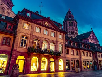 Historic buildings glow at night in a cityscape.