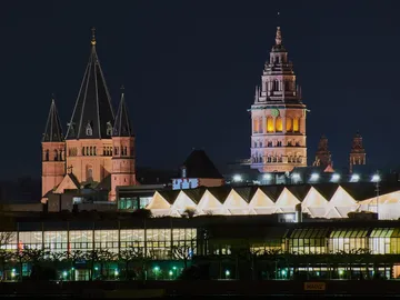 Skyscrapers glow at night, surrounded by urban architecture.