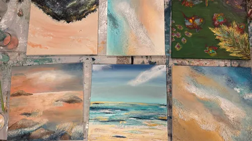 Six abstract paintings on a table.
