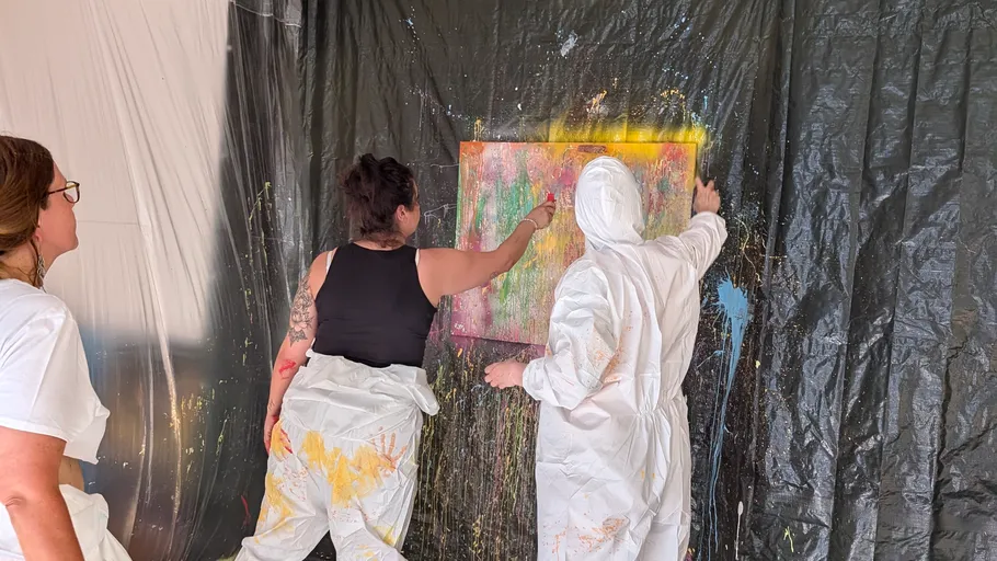 Zwei Personen malen auf Leinwand im Studio.