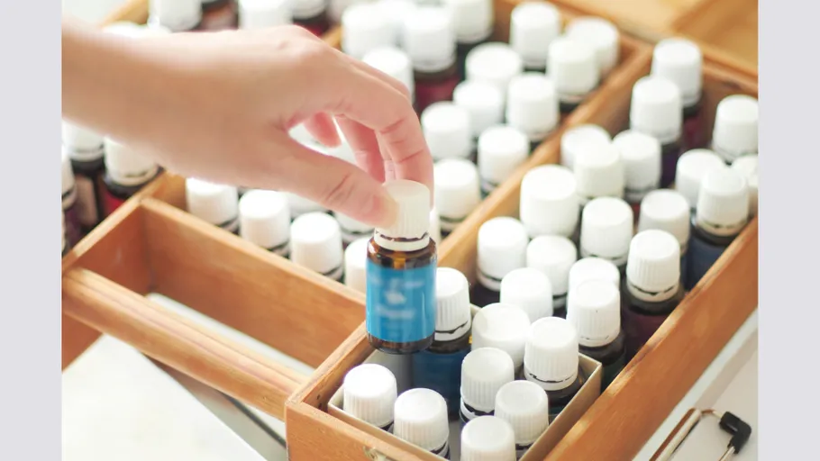 Hand selecting a bottle from wooden box.