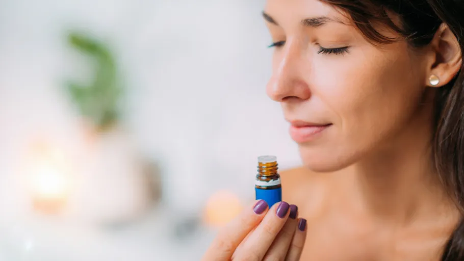 Woman smelling essential oil in a peaceful room.