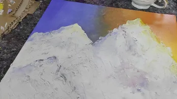 Colorful mountain painting on textured paper.