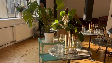 Indoor cafe with plants and small tables.