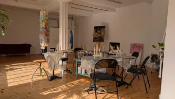Art studio with easels and hung canvas.