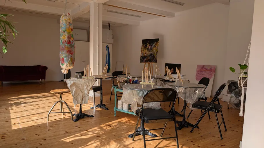 Art studio with easels and hung canvas.