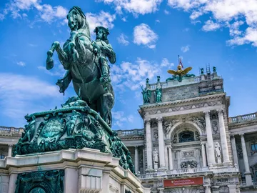 Equestrian statue stands in front of a reconstructed historic building.
