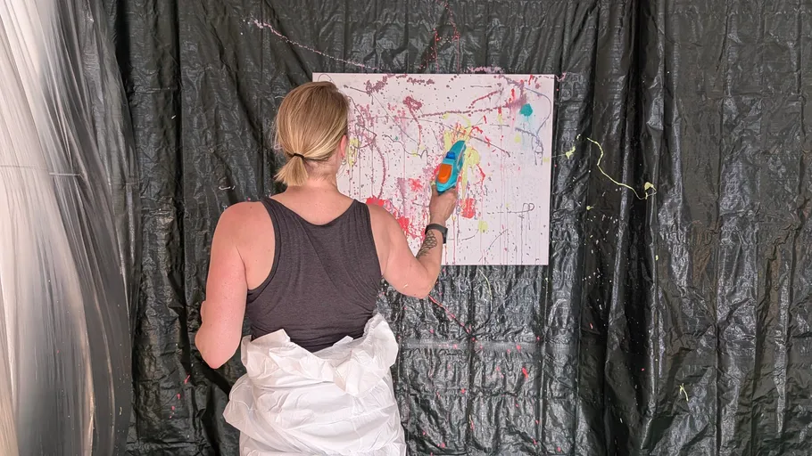 Person malt buntes abstraktes Kunstwerk auf Leinwand.