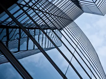 Modern buildings reflect the sky in smooth glass.