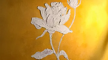 Geprägte weiße Rose auf goldenem Hintergrund.