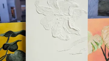 Weiße geprägte Blume auf strukturiertem Leinwand.
