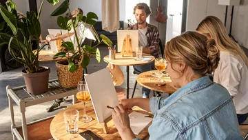 Menschen malen in entspannter Studioatmosphäre.