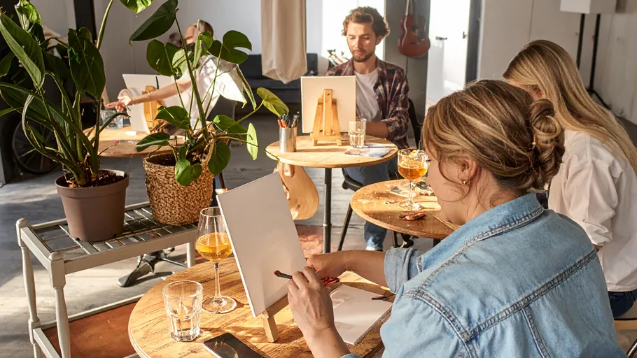 Menschen malen in entspannter Studioatmosphäre.