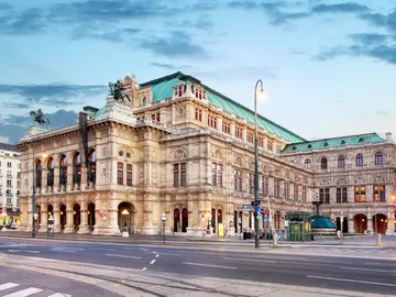 Magnificent building stands on the side of the road under a sky.