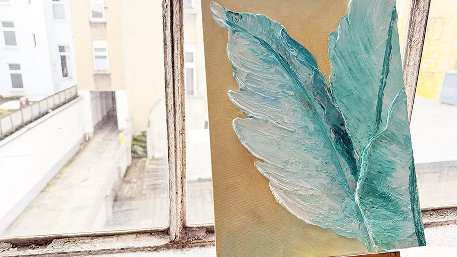 Strukturiertes Kunstwerk auf Staffelei am Fenster.