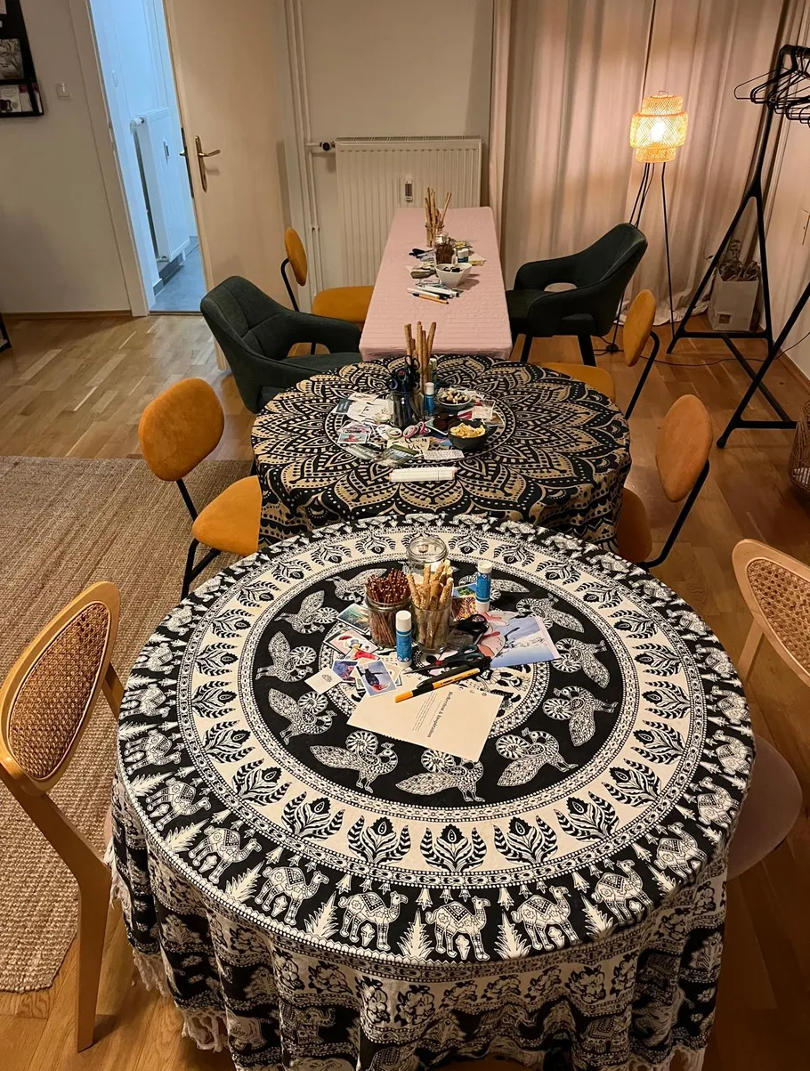 Two tables with art supplies, wooden floor.