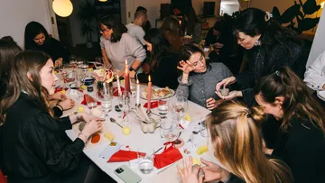 Personen basteln an einem Esstisch-Treffen.
