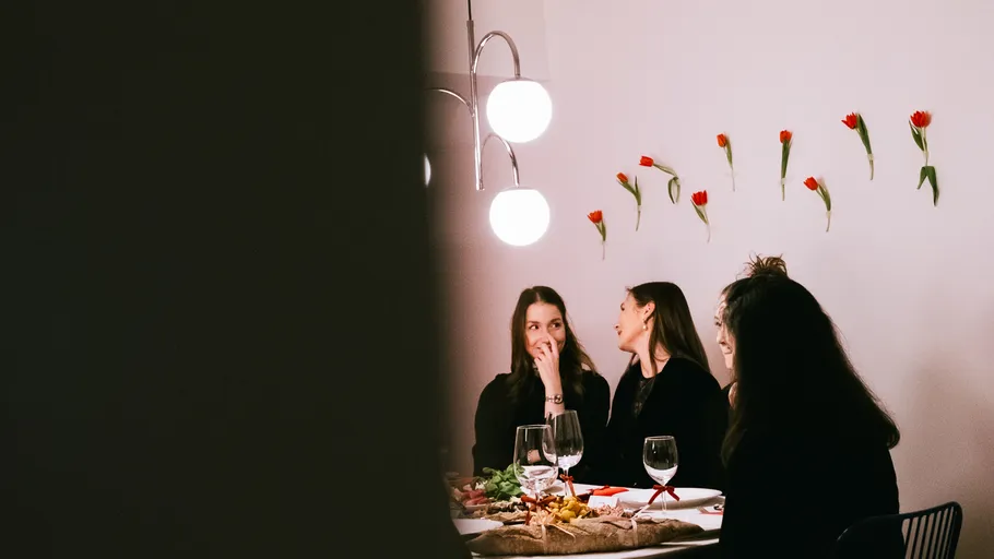 Drei Frauen essen an einem stilvollen Tisch.