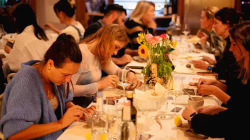 People crafting clay items at a long table.