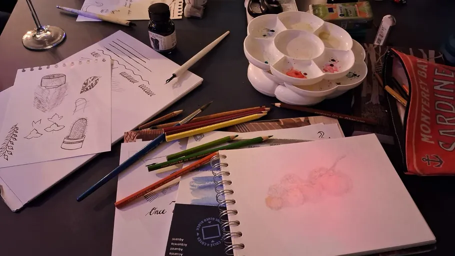 Kunstbedarf auf einem überfüllten Schreibtisch.