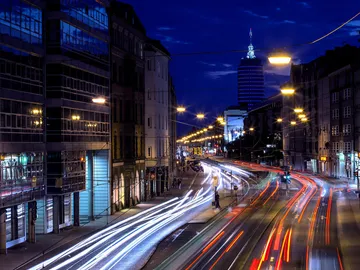 City street with lights, cars driving at night.
