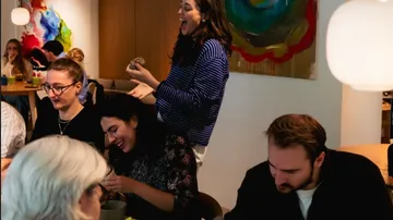 Menschen lachen und essen in einem Café.