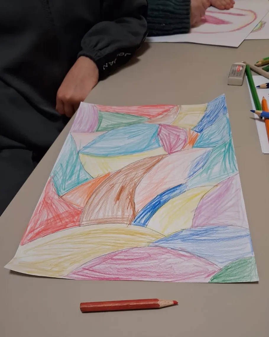 Colorful drawing on table, two people nearby.