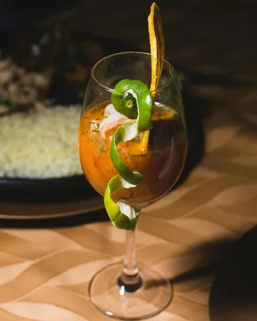 Glas mit Garnitur auf einem Tisch.