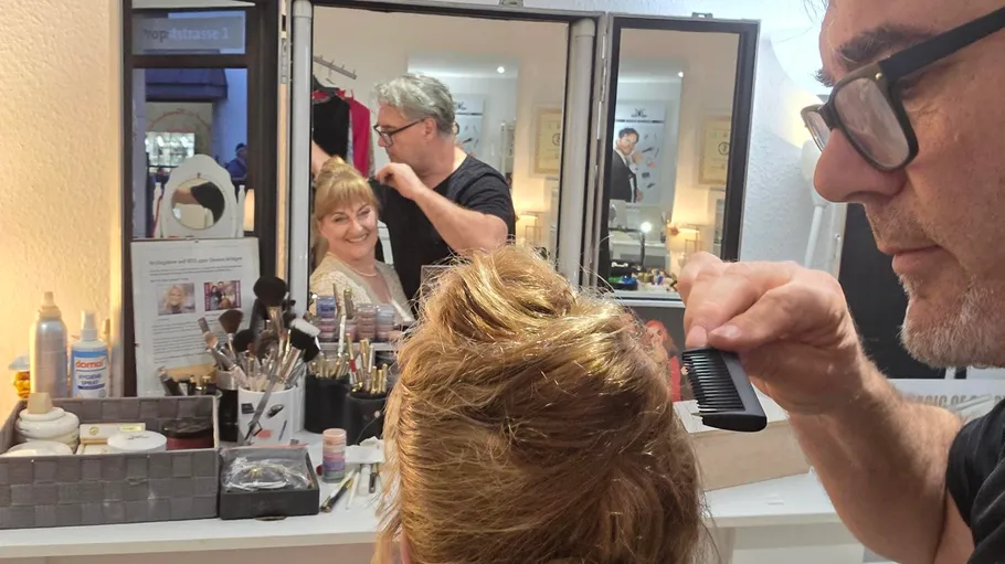Hairdresser styling woman's hair in a salon.