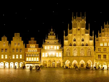 Historic buildings shine at night, people move comfortably.