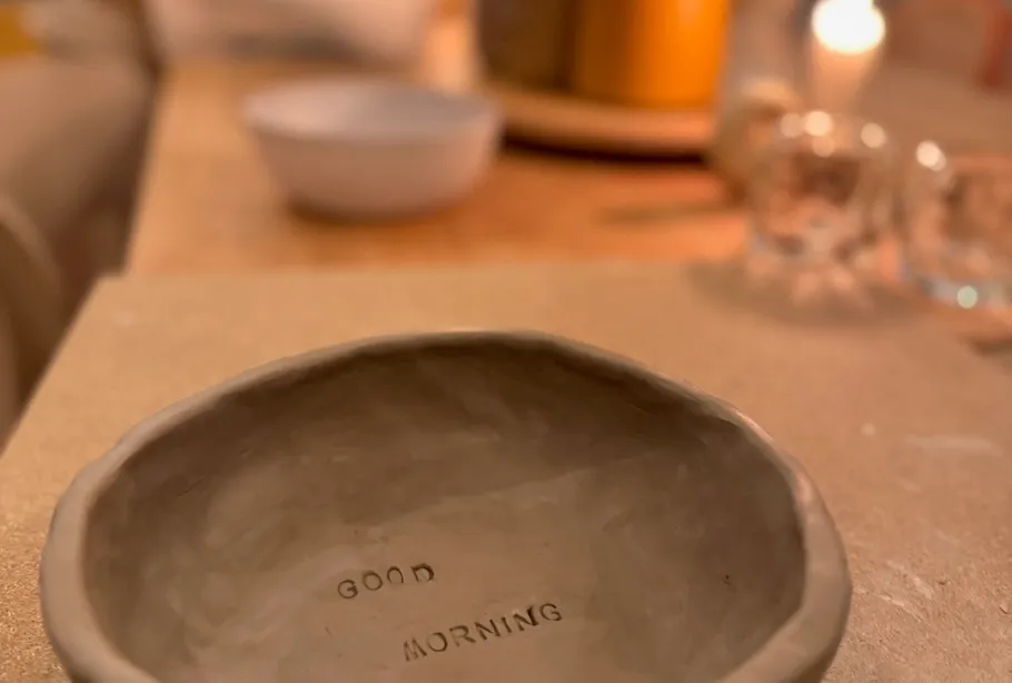Ceramic bowl with 'Good Morning,' cozy setting.