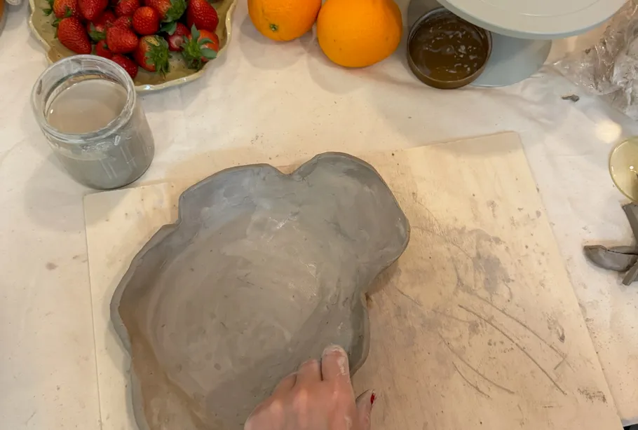 Hand formt Tonschale auf Tisch.