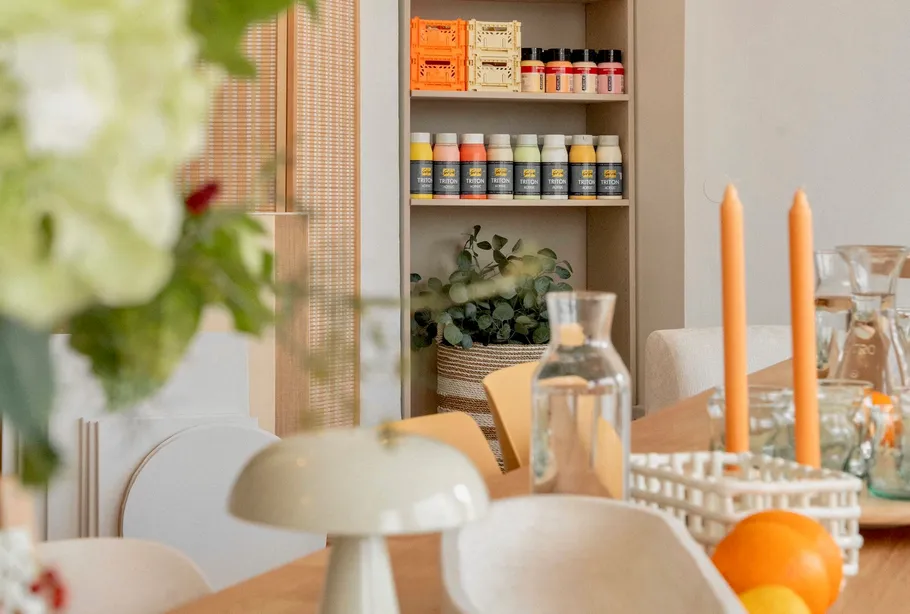 Dining table with candles and shelf behind.