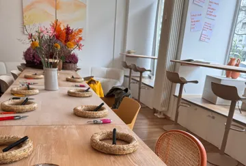 Tisch mit Blumenarrangement-Zubehör in hellem Raum.