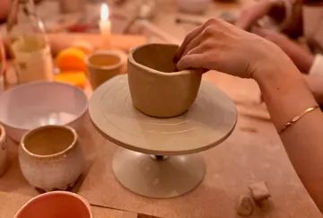 Hand formt Tongefäß auf einem Drehteller.