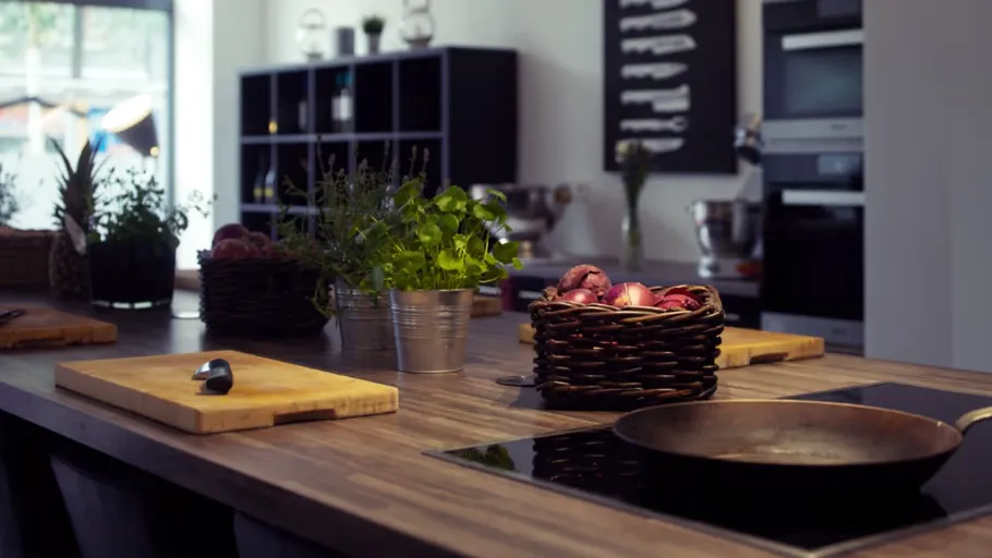 Kitchen counter with herbs and cookware.