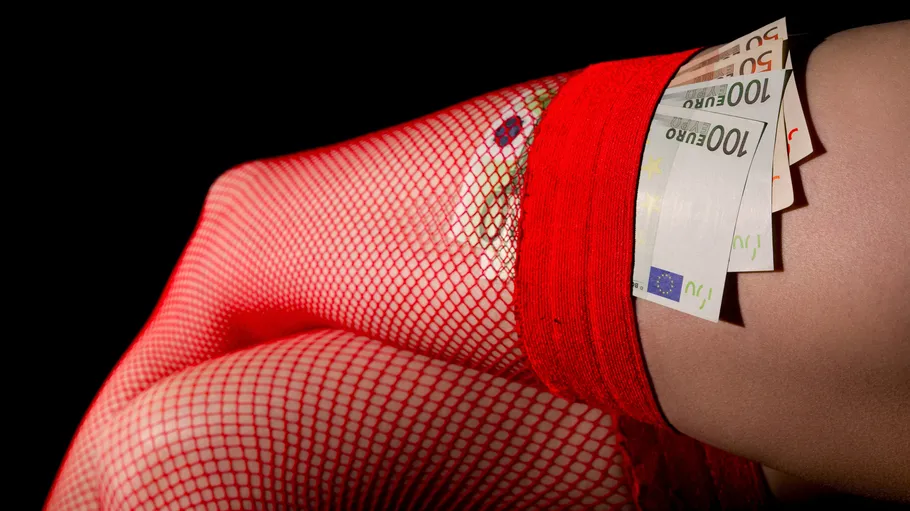 Bein in roten Netzstrümpfen mit Euro-Scheinen.