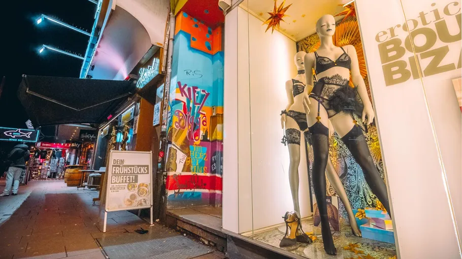 Schaufensterpuppen in Dessous, Straßenszene bei Nacht.