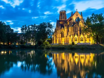 A church is reflected in the water at night.
