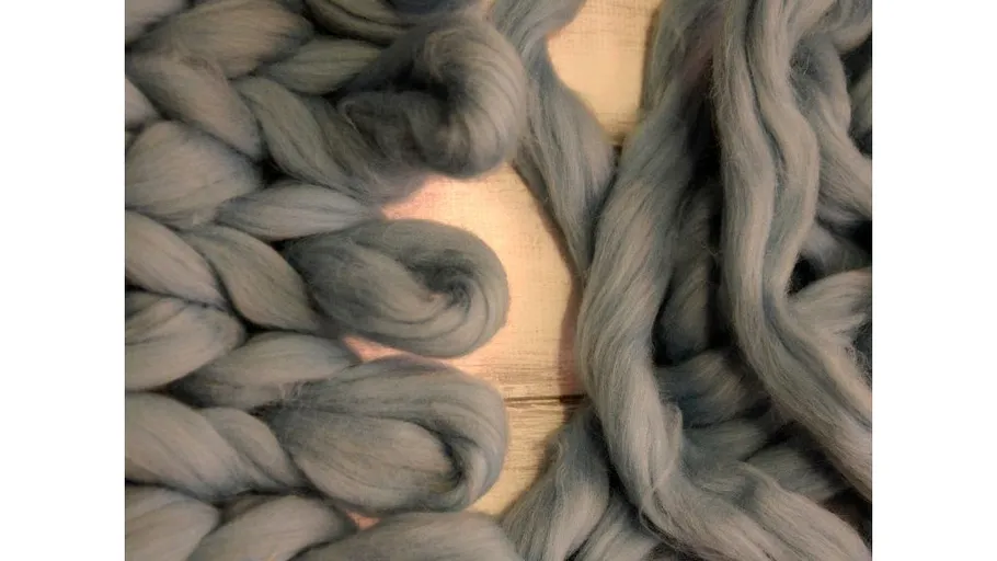Blue wool strands on wooden surface.