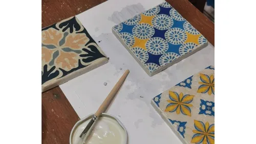 Colorful tiles and paintbrush on table.
