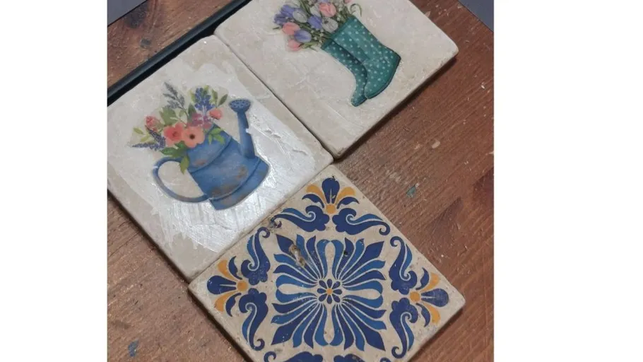 Three decorated tiles on wooden surface.